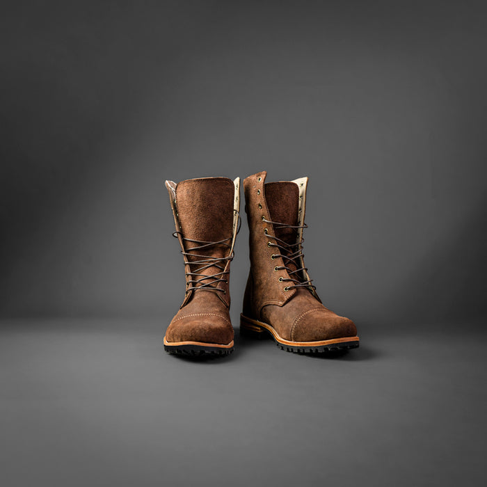 par de botas cafe oscuro estilo militar  C&A boots en un fondo gris